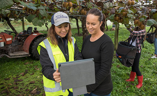Primary industries tutor and student looking at a laptop during a field trip