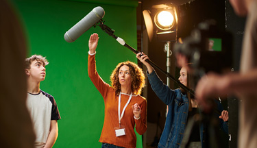 Tutor teaching students on set