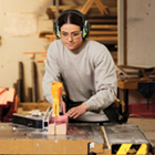 Carpentry student using saw to cut wood