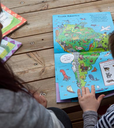 Teacher reading a book with a child 