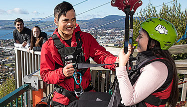 Tourism and Travel student hooking a visitor onto a zipline 