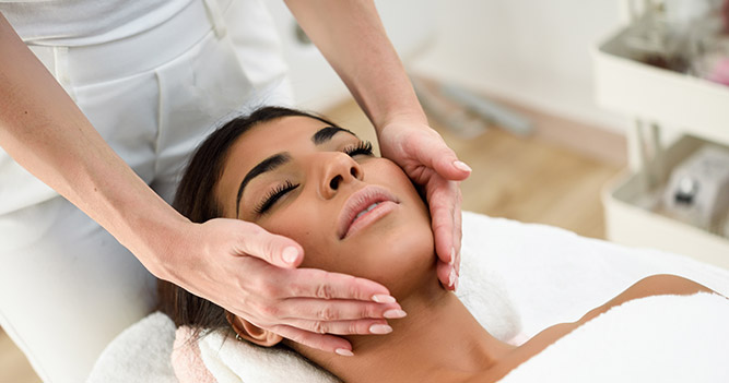 Beauty student massaging clients face