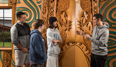 Students learning about the carvings in Tangatarua Marae