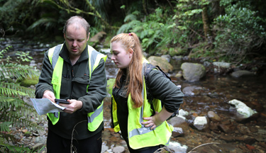 Conservation operation students looking over coordinates on a map Conservation operation students looking over coordinates on a map
