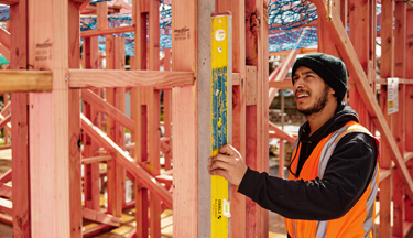 Carpentry student checking house frames are level Carpentry student checking house frames are level