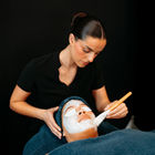 Beauty therapy student applying facial cream to client Beauty therapy student applying facial cream to client