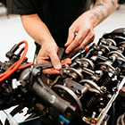 Automotive student working on a car engine Automotive student working on a car engine